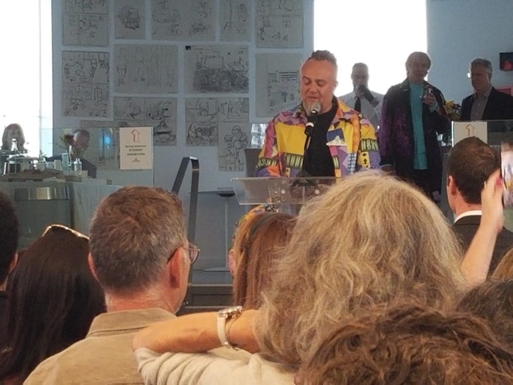 Man with colorful shirt speaking at an arts event in Norwalk CT