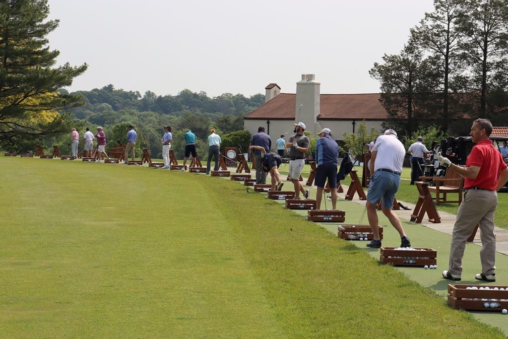 Golfers lined up to take drives.